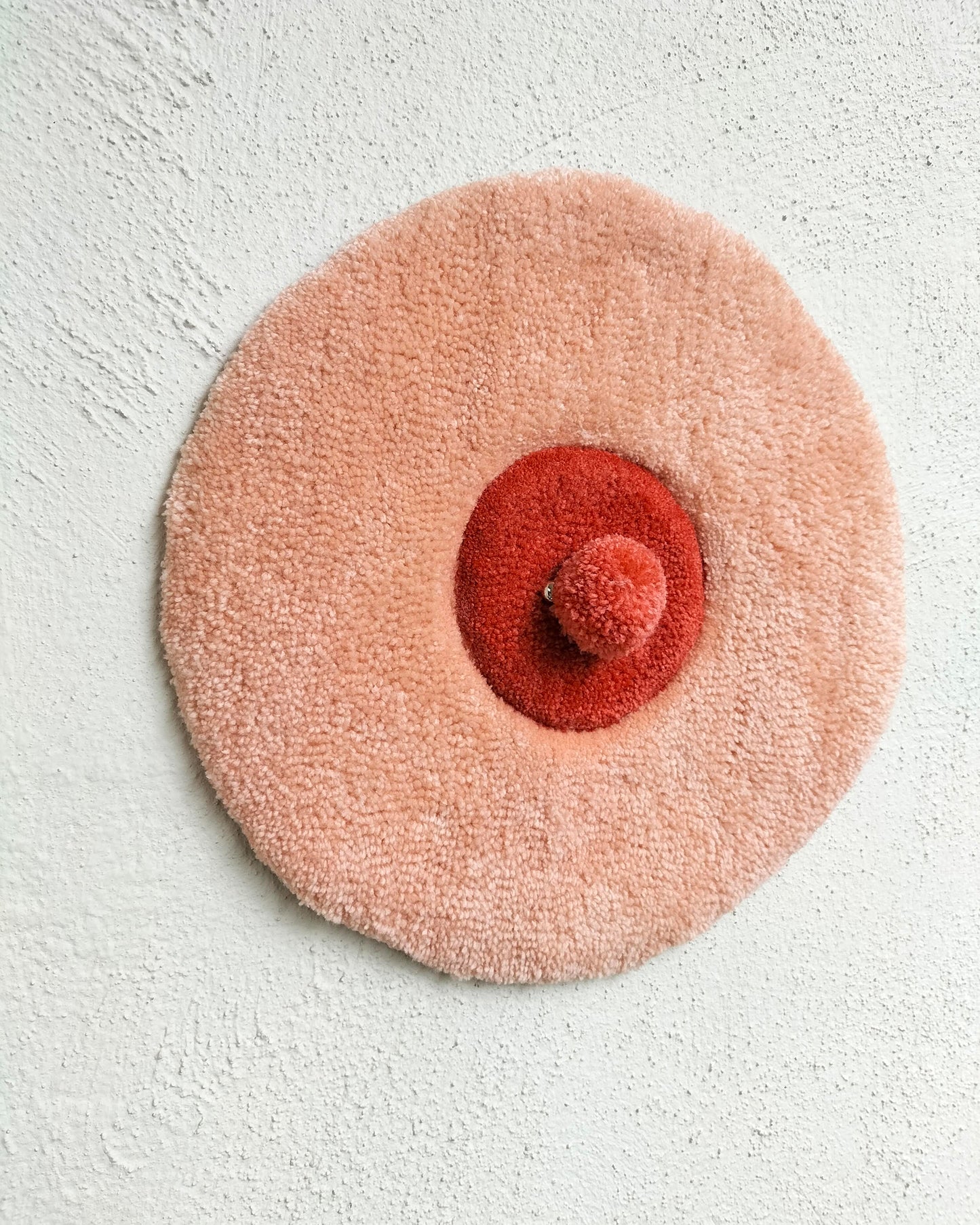 Handmade tufted boobie wall art with piercing in peach and red yarn, feminist decor