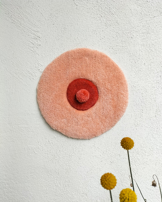 Handmade tufted boobie wall art with piercing in peach and red yarn, feminist decor